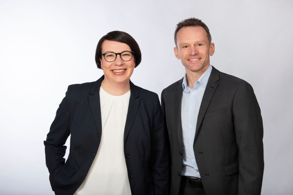 Ein Mann und eine Frau mittleren Alters sehen lächelnd in die Kamera Ein Mann und eine Frau mittleren Alters sehen lächelnd in die Kamera