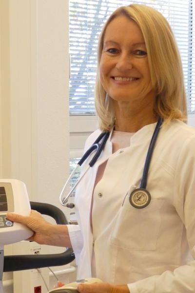 Eine Ärztin mitleren Alters sieht lächelnd in die Kamera Eine Ärztin mitleren Alters sieht lächelnd in die Kamera