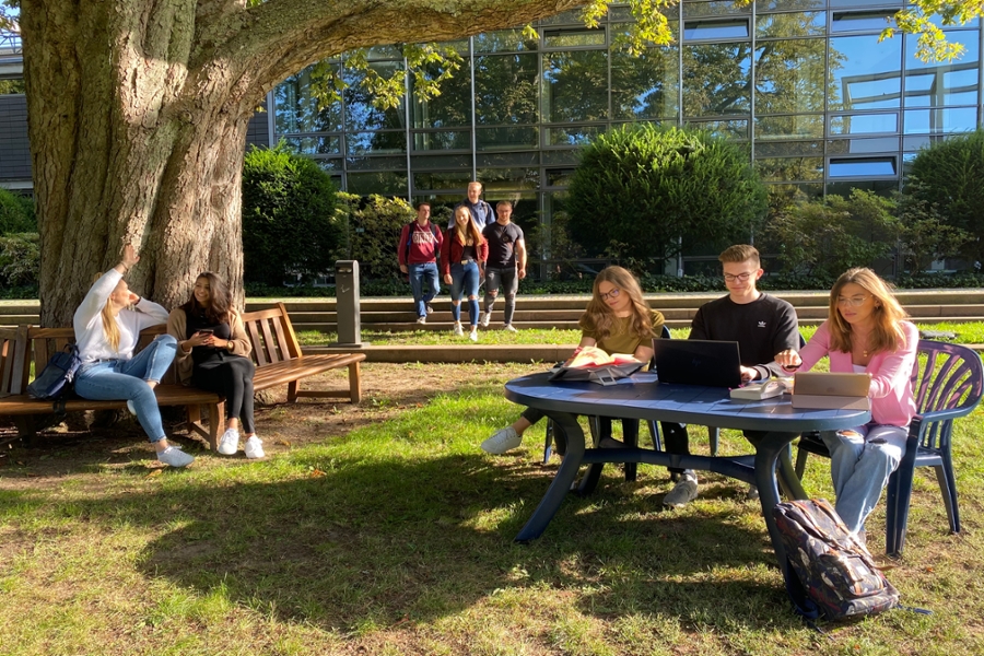 Studierende lernen und entspannen auf dem Außengelände vom Campus Reinfeld