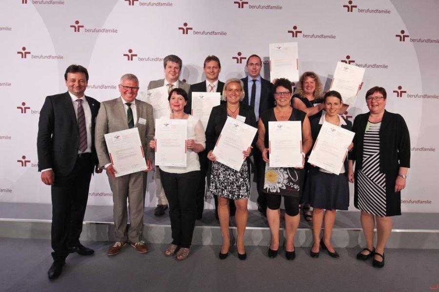 Mehrere Menschen halten stolz ein Zertifikat in den Händen und in die Kamera Mehrere Menschen halten stolz ein Zertifikat in den Händen und in die Kamera