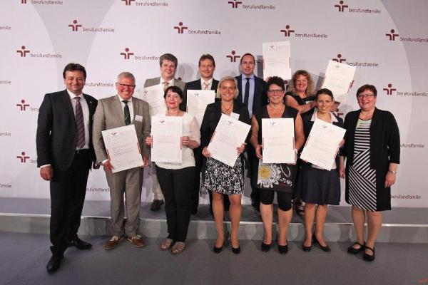 Mehrere Menschen halten stolz ein Zertifikat in den Händen und in die Kamera Mehrere Menschen halten stolz ein Zertifikat in den Händen und in die Kamera