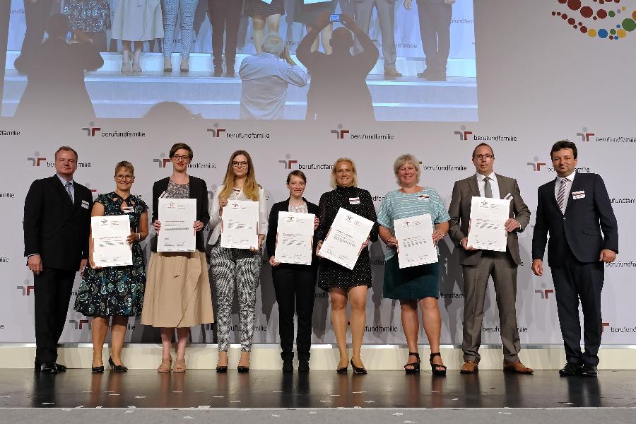 Mehrere Menschen halten stolz ein Zertifikat in den Händen und in die Kamera Mehrere Menschen halten stolz ein Zertifikat in den Händen und in die Kamera