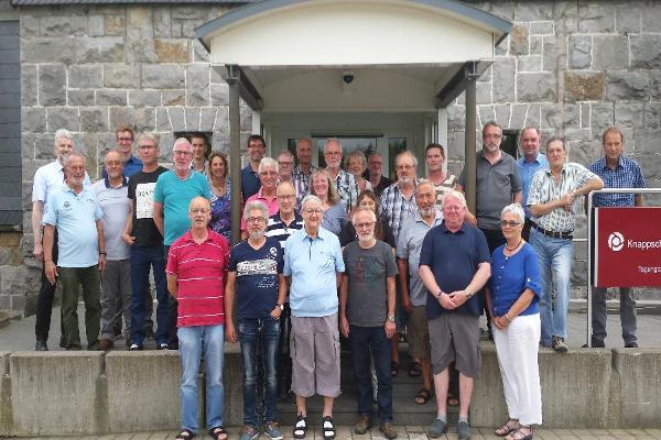 Männer und Frauen verschiedenen Alters stehen vor dem Eingangsbereich des Bildungszentrums in Winterberg. Männer und Frauen verschiedenen Alters stehen vor dem Eingangsbereich des Bildungszentrums in Winterberg.