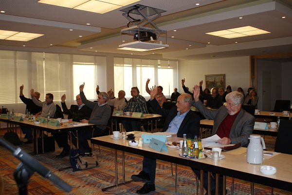 Mehrere Leute stimmen während einer Sitzung mit erhobenem Finger ab Mehrere Leute stimmen während einer Sitzung mit erhobenem Finger ab
