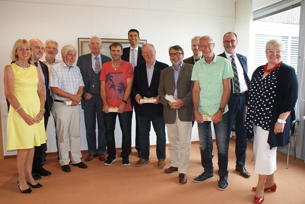 Mehrere Leute sehen lächelnd in die Kamera und haben kleine Präsente in den Händen Mehrere Leute sehen lächelnd in die Kamera und haben kleine Präsente in den Händen