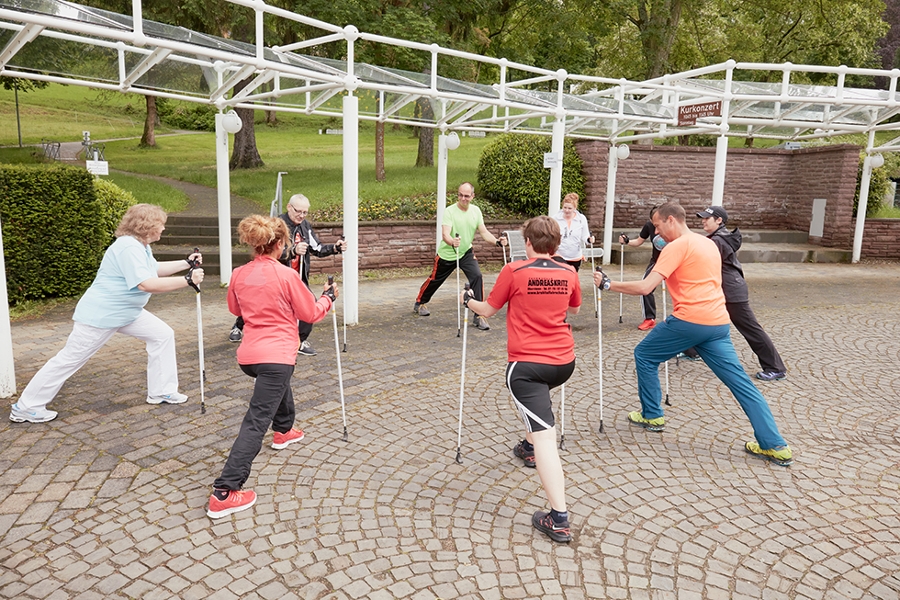 Eine Gruppe mit Walkingstöcken dehnt sich im Freien. Eine Gruppe mit Walkingstöcken dehnt sich im Freien.