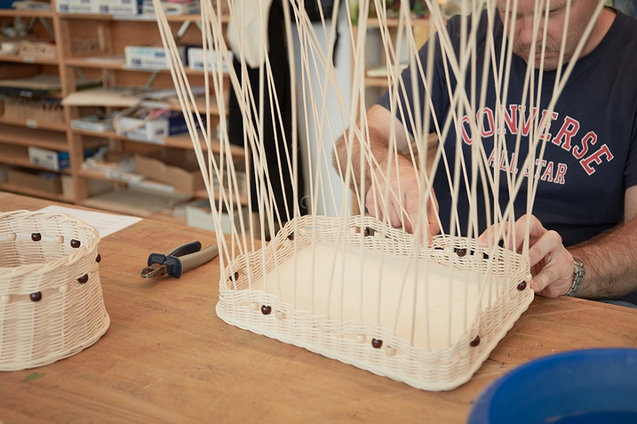 Eine Person flechtet einen Korb. Eine Person flechtet einen Korb.