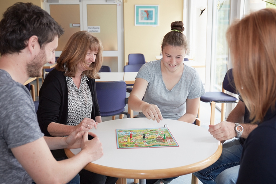 Vier Personen spielen an einem Tisch. Vier Personen spielen an einem Tisch.