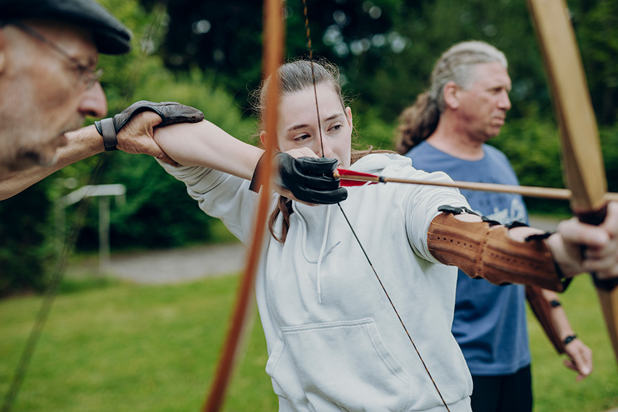 eine Rehabilitandin beim Bogenschießen eine Rehabilitandin beim Bogenschießen