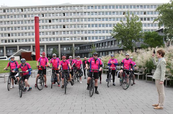 Eine Gruppe Rennradfahrer stehen startbereit und warten auf den Startschuss. 