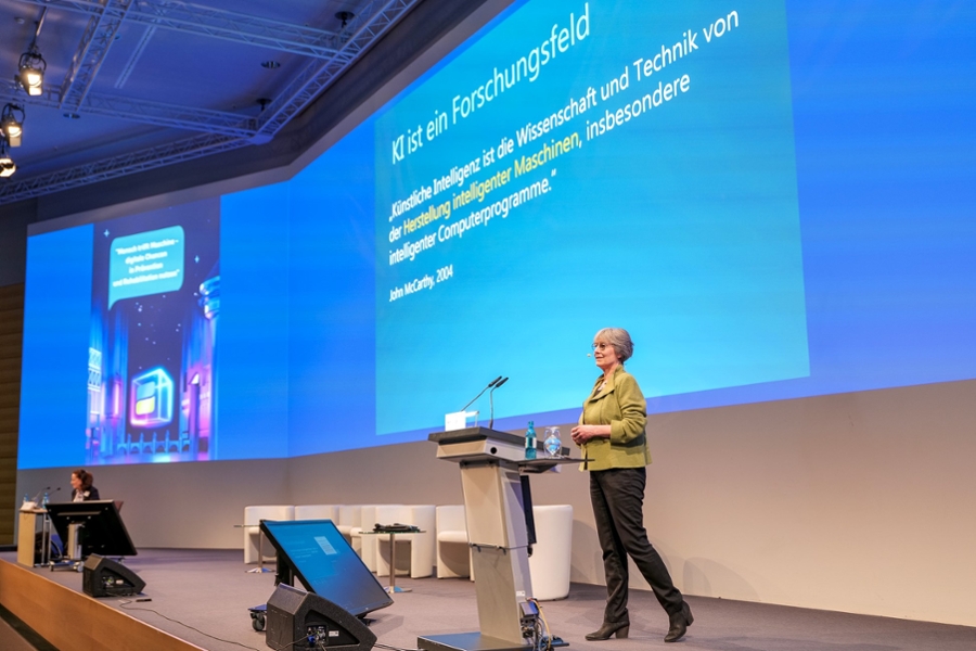 Eine Frau hält auf der Bühne einen Vortrag. Eine Frau hält auf der Bühne einen Vortrag.