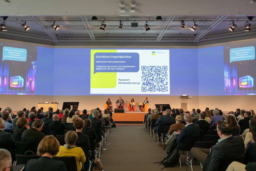 Menschen sitzen auf einer Bühne vor Publikum und diskutieren. Menschen sitzen auf einer Bühne vor Publikum und diskutieren.