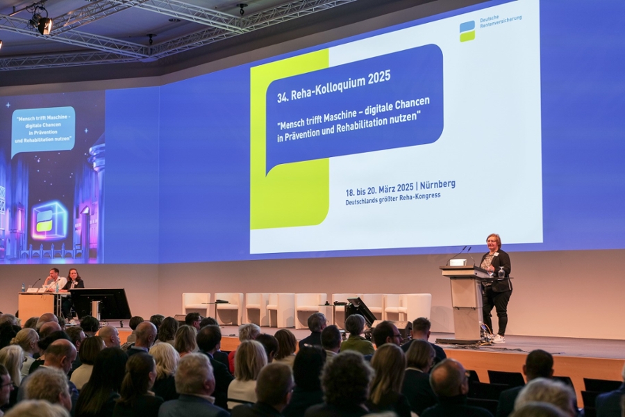 Eine Frau steht auf der Bühne und spricht zu Menschen. Eine Frau steht auf der Bühne und spricht zu Menschen.