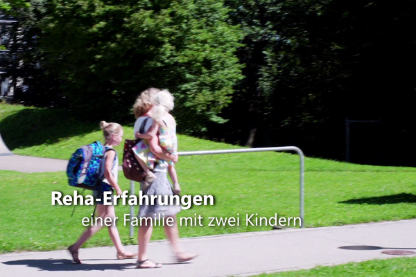 Eine Frau mit Kind auf dem Arm und ein Mädchen gehen einen Weg entlang Eine Frau mit Kind auf dem Arm und ein Mädchen gehen einen Weg entlang