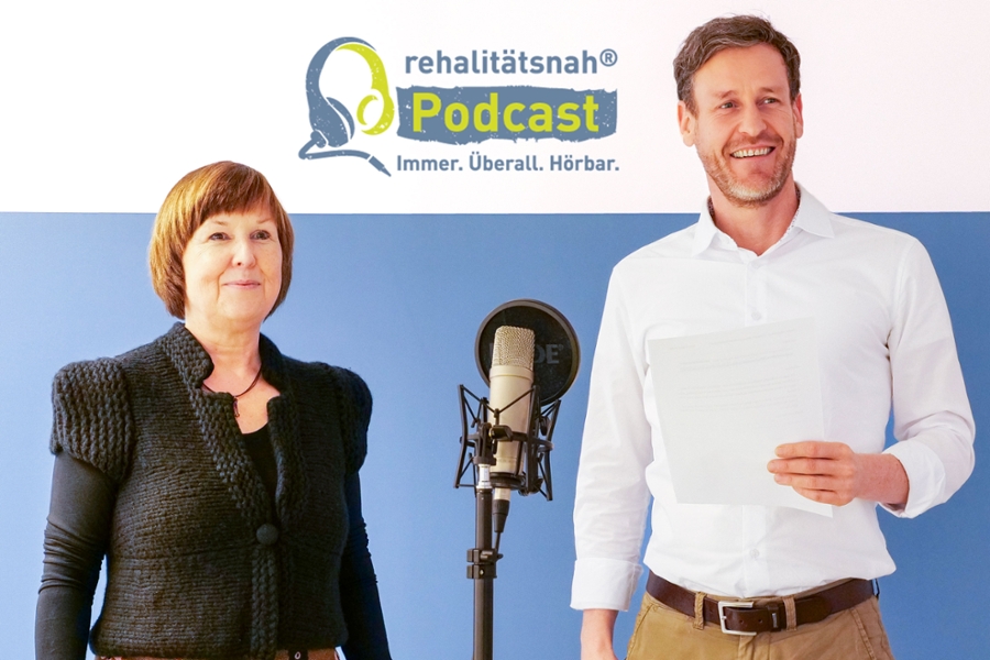 Ein Mann und eine Frau stehen neben einem großen Mikrofon Ein Mann und eine Frau stehen neben einem großen Mikrofon