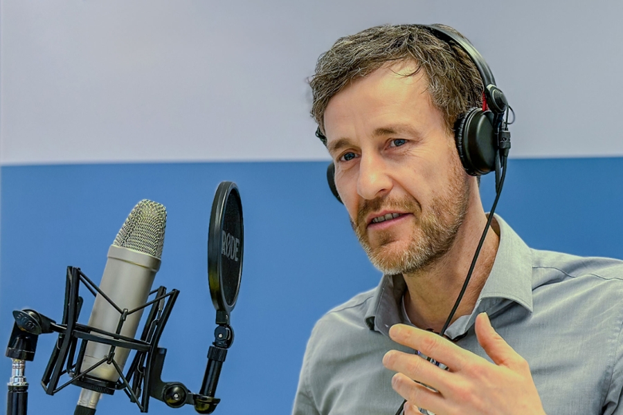 Ein Mann spricht in ein großes Mikrofon Ein Mann spricht in ein großes Mikrofon