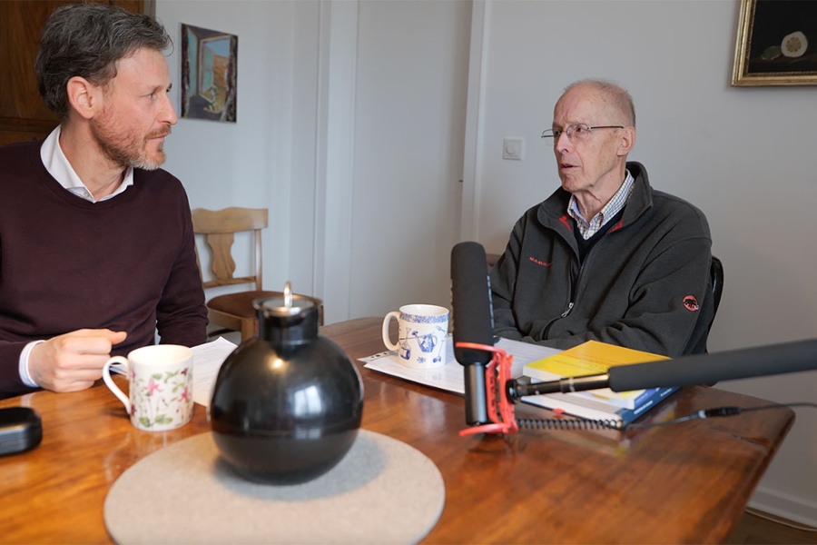 Zwei Männer sitzen vor einem großen Mikrofon Zwei Männer sitzen vor einem großen Mikrofon